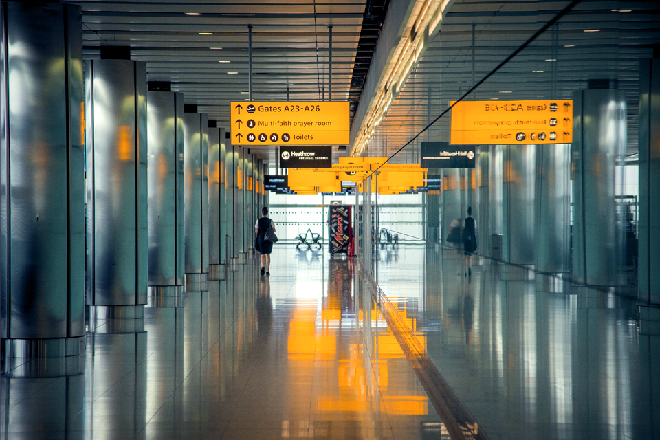 A woman walks through Heathrow airpor